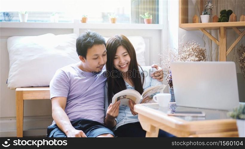 Couple of Asian Lover sitting together and reading book in the morning with warm feeling at modern co-working space, Lifestyle and leisure with love concept