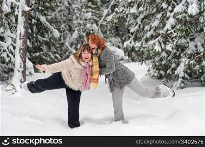 Couple of attractive friends having fun on winters day in forest.