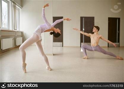 Couple of ballet dancers, dancing repetition. Ballerina with partner training in class, dance studio interior on background. Couple of ballet dancers, dancing repetition