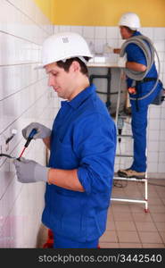 Couple of electricians wiring a building