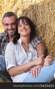 couple of farmers all smiles posing in barn