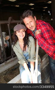 Couple of farmers standing in barn