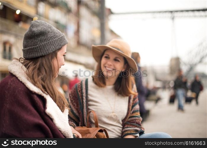 Couple of friends talking in the city with winter clothes