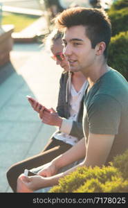 Couple of friends, teenage girl and boy, having fun together, sitting in center of town, spending time together