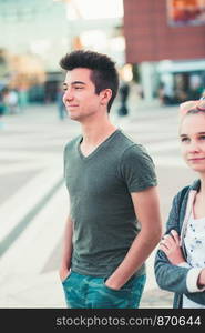 Couple of friends, teenage girl and boy, having fun together, walking in center of town, spending time together