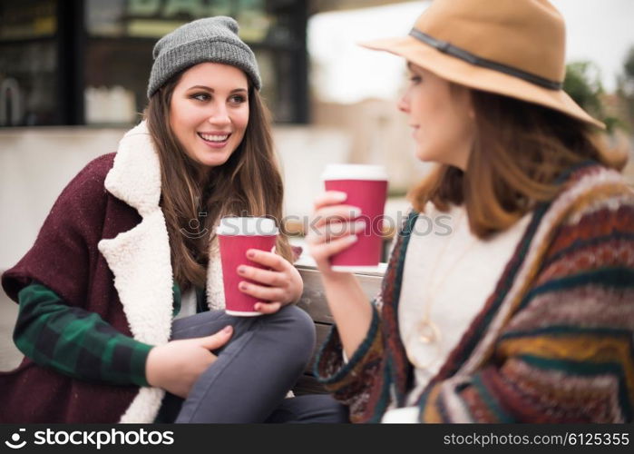 Couple of friends with hot drink on winter