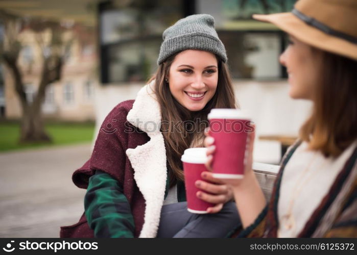 Couple of friends with hot drink on winter