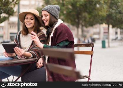 Couple of girls watching funny videos on a digital tablet