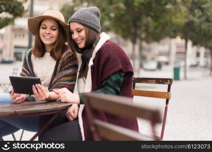 Couple of girls watching funny videos on a digital tablet