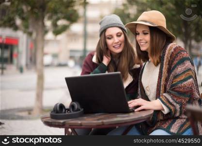 Couple of girls watching funny videos on a laptop