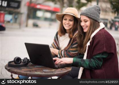 Couple of girls watching funny videos on a laptop