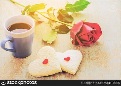 Couple of heart shape white bread with coffee cup and red rose. Photo is focused at the bread.