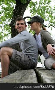 Couple of hikers sitting on a table outdoors
