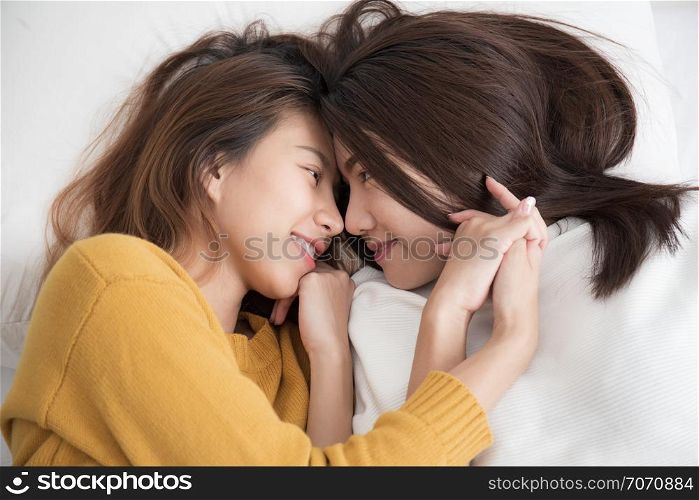 Couple of homosexual women on white bed,Lesbians Asian women are smiling and catching on white bed