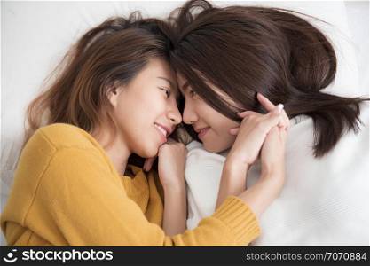 Couple of homosexual women on white bed,Lesbians Asian women are smiling and catching on white bed