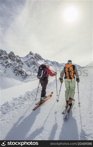 Couple of retired sporty friends engage in ski mountaineering