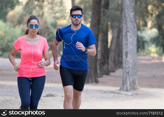 couple of runners exercising in a park and listening to music.