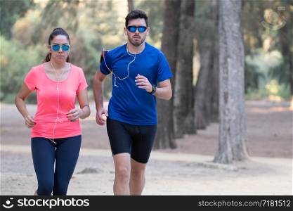 couple of runners exercising in a park and listening to music.