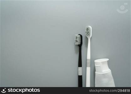 couple of toothbrush with toothpaste on gray background
