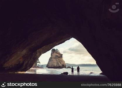 Couple of tourists in the Cathedral Cove, Coromandel Peninsula, New Zealand
