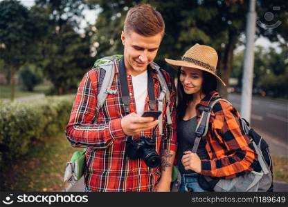 Couple of tourists looking for city attractions on navigator, excursion in town. Summer hiking. Hike adventure of young man and woman