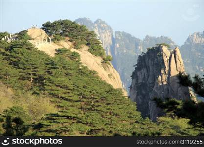 Couple of tourists on the top of rock in Huangshan mountain, China