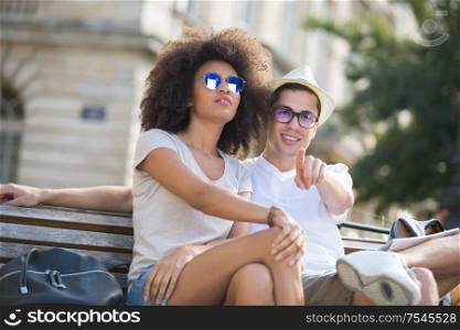 couple of tourists sitting and pointing at horizon on vacations
