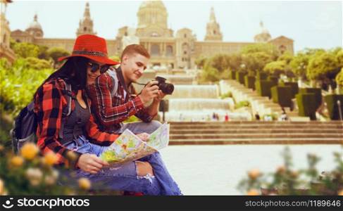 Couple of tourists study the map of ancient temple. Summer adventure of young man and woman, photo for memory