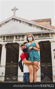 Couple of tourists with face masks in front of the Bermeo Panteon in Vizcaya, Spain