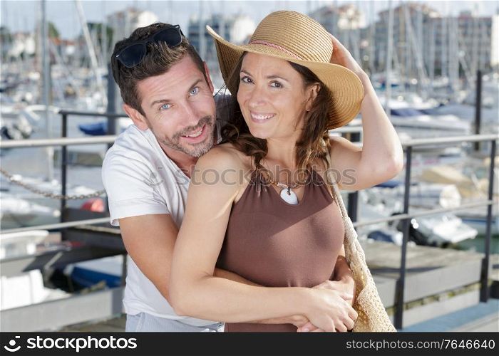 couple of travelers are hugging in sea yacht port