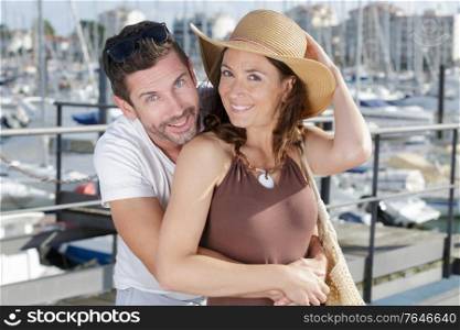 couple of travelers are hugging in sea yacht port