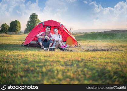 Couple of travelers spending time in tent near campfire. Couple of travelers