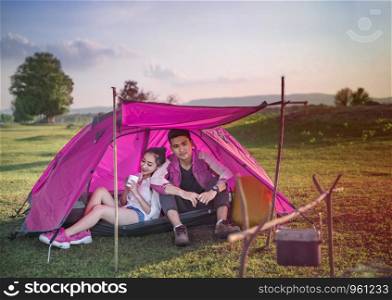 Couple of travelers spending time in tent near campfire. Couple of travelers