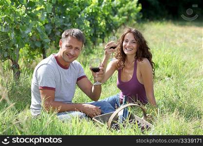 Couple of winegrowers drinking wine in vineyard