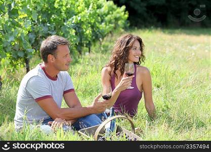 Couple of winegrowers drinking wine in vineyard