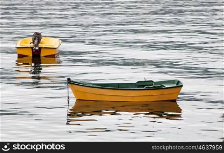 Couple of yellow boats floating on a calm sea