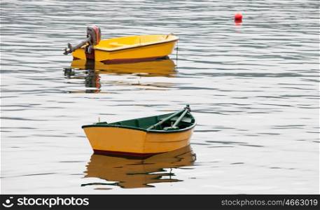 Couple of yellow boats floating on a calm sea&#xA;