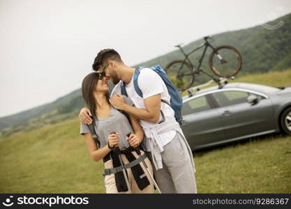 Couple of young hikers with backpacks starting a walk through the fields