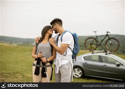 Couple of young hikers with backpacks starting a walk through the fields