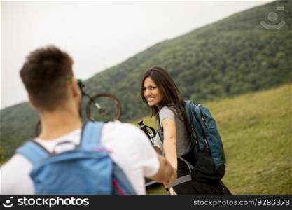 Couple of young hikers with backpacks starting a walk through the fields
