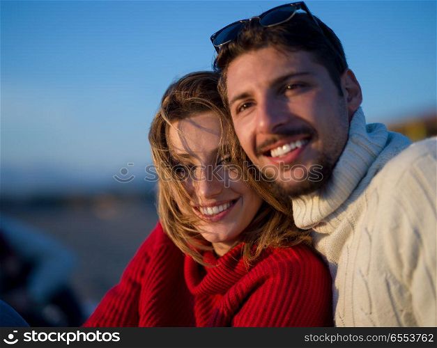 couple on a beach at autumn sunny day. portrait of young couple having fun on beach during autumn sunny day