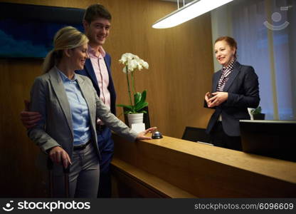 Couple on a business trip doing check-in at the hotel