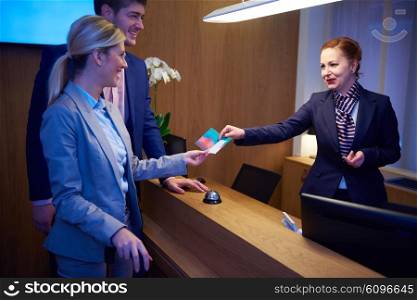 Couple on a business trip doing check-in at the hotel