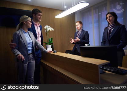 Couple on a business trip doing check-in at the hotel