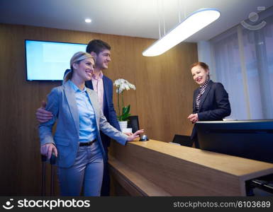 Couple on a business trip doing check-in at the hotel