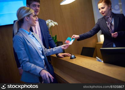 Couple on a business trip doing check-in at the hotel