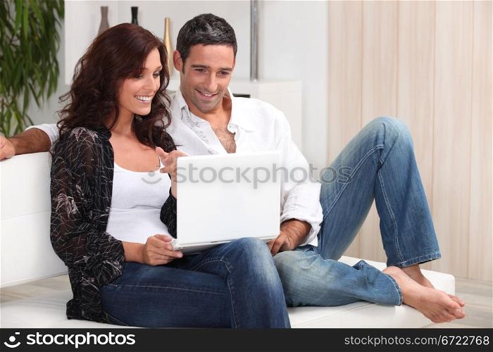 Couple on a sofa with a laptop