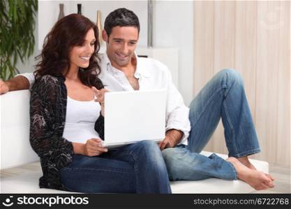 Couple on a sofa with a laptop