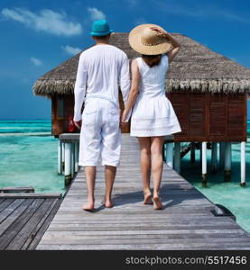 Couple on a tropical beach jetty at Maldives