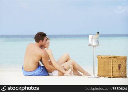 Couple On Beach With Luxury Champagne Picnic